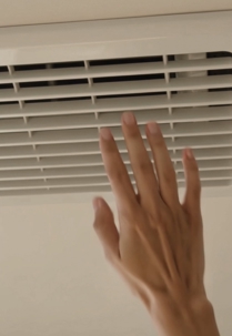 Hand checking weak airflow from upstairs supply vent in Carlsbad CA home